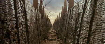 A brick corridor stretches off into the distance. Ferns grow from the brickwork and roots stretch across the path.