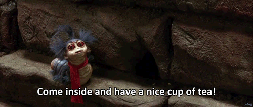 Animated worm with blue hair and a red scarf, saying "Come inside and have a nice cup of tea!"